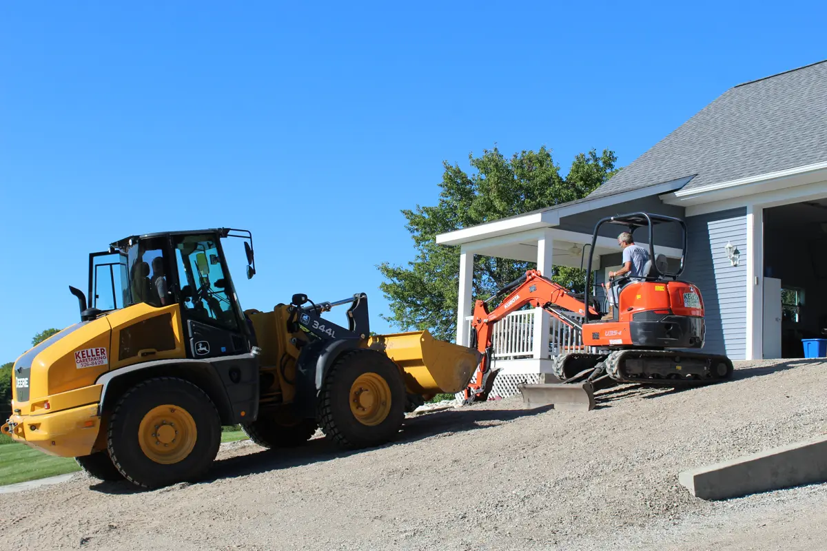 Heavy equipment grading a residential driveway in Harbor Springs
