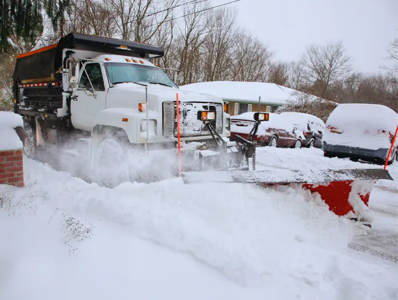 Truck plowing snow on a residential driveway